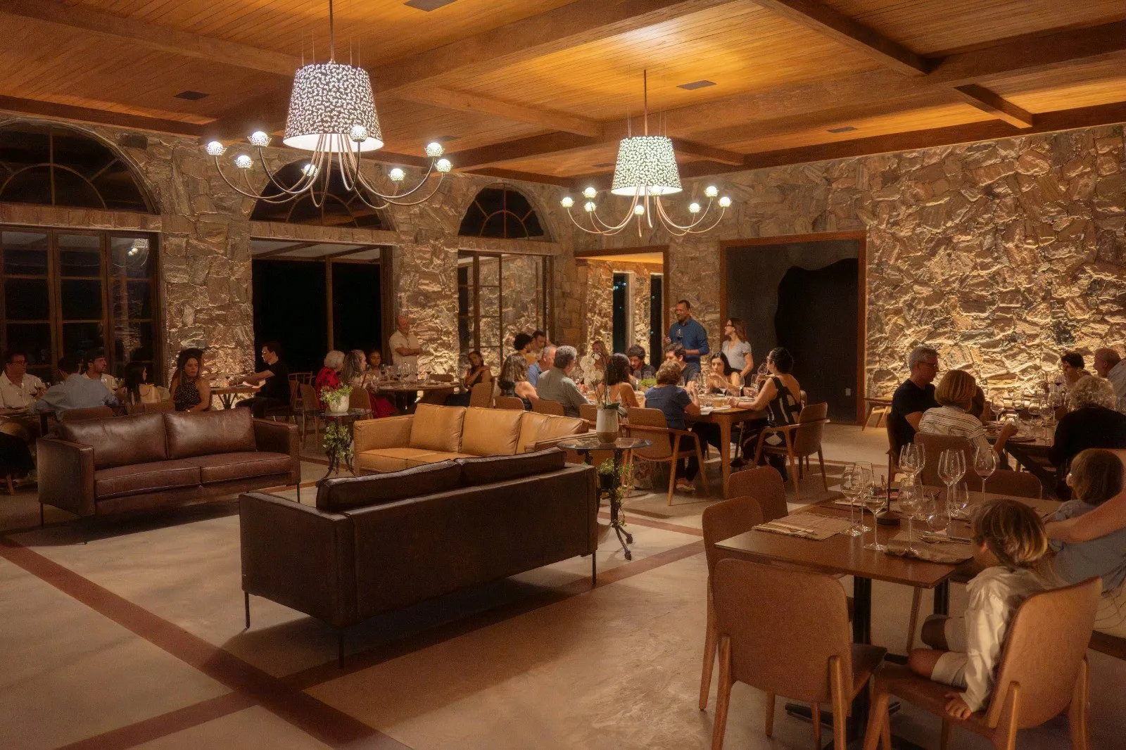 Salão da Casa Vinnus à noite, com lustres e mesas ocupadas